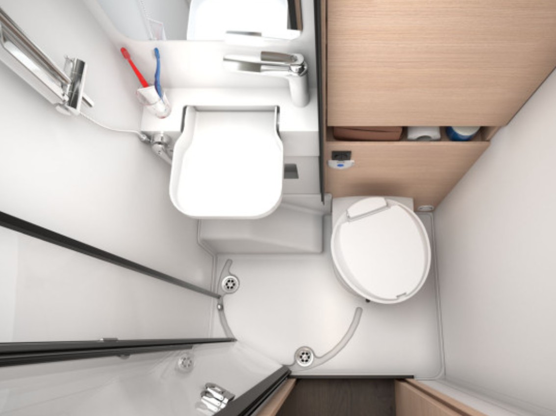 Ruimtelijke badkamer van de Sun Living S72DL camper met een wastafel, spiegel, toilet en douche, uitgevoerd in lichte kleuren voor een frisse uitstraling